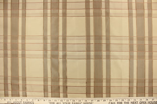 This fabric features a plaid design in beige, taupe, gold, and light mauve .