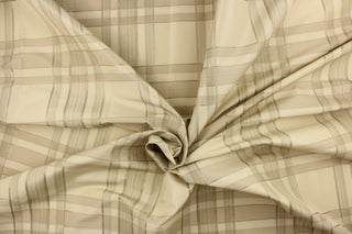  This fabric features a plaid design in off white, light khaki, light beige, and hints of gray.