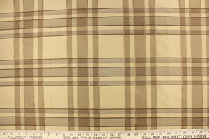 This fabric features a plaid design in beige, taupe, dark brown and gold.