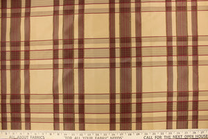 This fabric features a plaid design in deep red, tan, and dark brown.