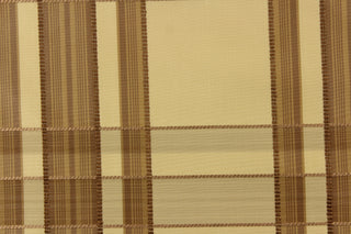 This fabric features a plaid design in beige, brown, gold, and dark brown . 