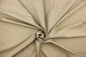 This yarn dye stripe fabric features a small plaid or checkered design in cream, khaki and gray or taupe. 