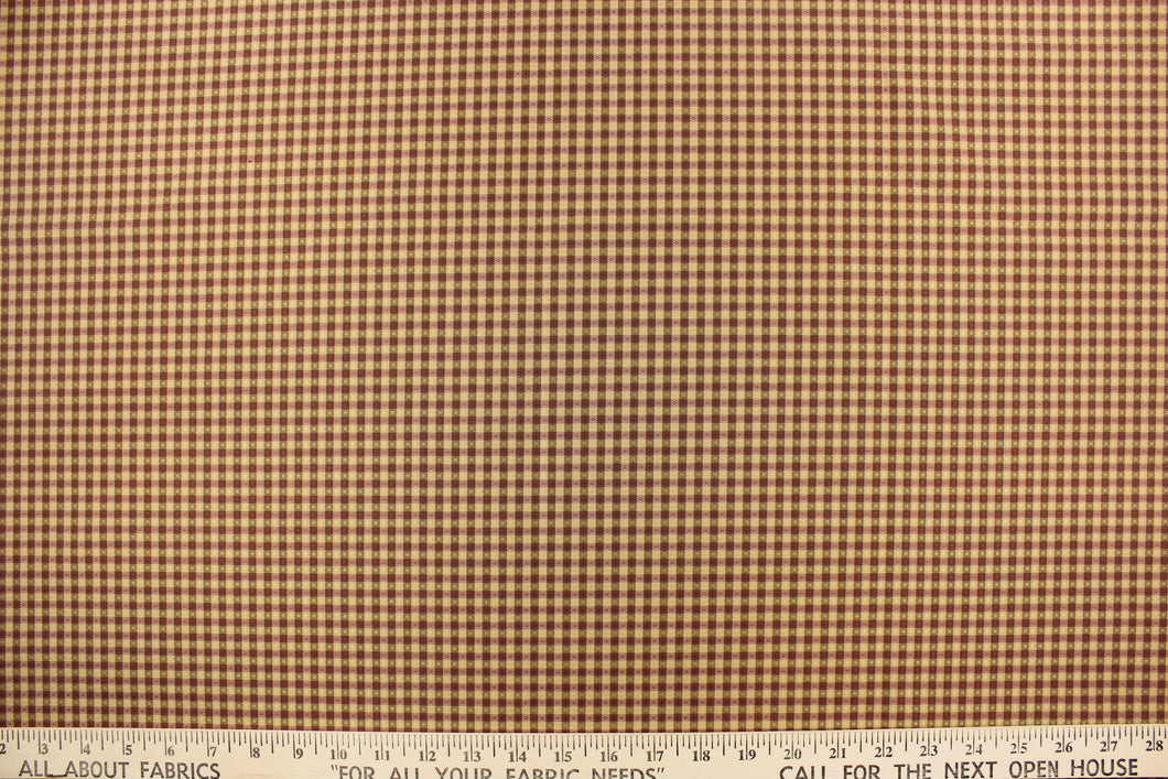  This yarn dye stripe fabric features a small plaid or checkered design in tan, brown and mauve.