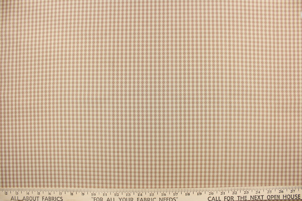 This yarn dye stripe fabric features a small plaid or checkered design in khaki and blush. 