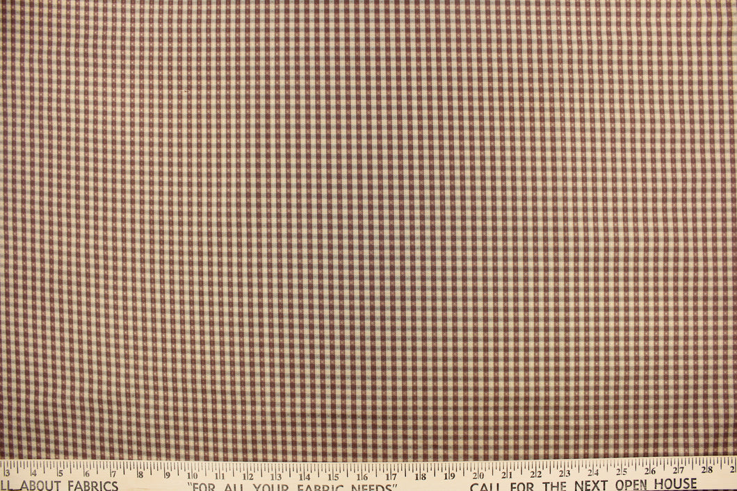 This yarn dye stripe fabric features a small plaid or checkered design in gray, taupe and washout maroon.