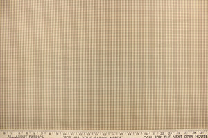 This yarn dye stripe fabric features a small plaid or checkered design in khaki, taupe and tan . 