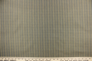  This stunning yarn dyed fabric features a small plaid design in blue, black, and golden tan or beige.