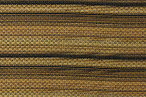   This jacquard fabric features a heavily striped pattern in shades of black, brown and gold. 