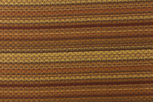 Load image into Gallery viewer, This jacquard fabric features a heavily striped pattern in shades of brown, gold and orange. 
