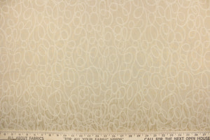 This jacquard fabric features interlocking circles in opal, beige and gold. 