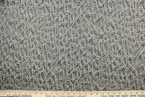 This jacquard fabric features interlocking circles in gray, stone and silver. 