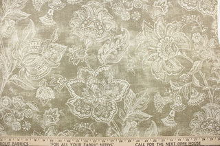 This fabric features a whimsical floral design in a off white against a grayish beige .