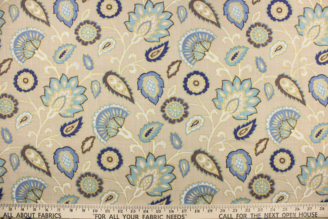 This fabric features a floral design in varying shades of blue, white, taupe, brown, and gold against a beige background.