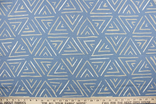 This fabric features a geometric design of triangles in gray and white against a light blue .