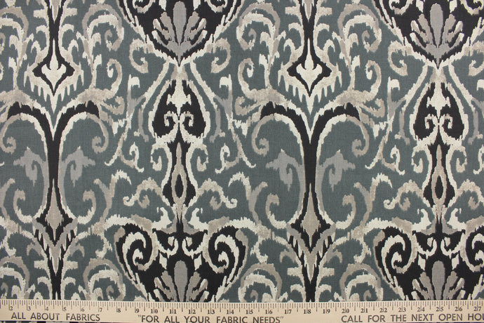  This beautiful fabric features a enteric ikat design in gray, black , taupe, off white and blue gray. 