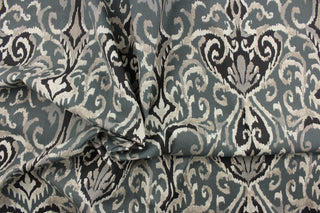  This beautiful fabric features a enteric ikat design in gray, black , taupe, off white and blue gray. 