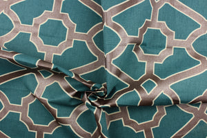 This fabric features a geometric design in dark bronze outline in off white against a teal background. 