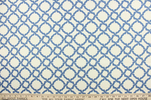 This fabric features a geometric design in blue against a dull white . 