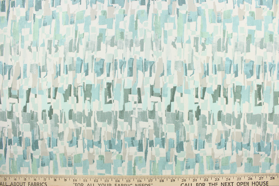 This fabric features an abstract design in light seafoam green, gray, turquoise, white and blue green. 