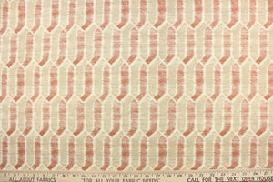 This fabric features a geometric design in shades of washout red and light beige with hints of gray and dull white .