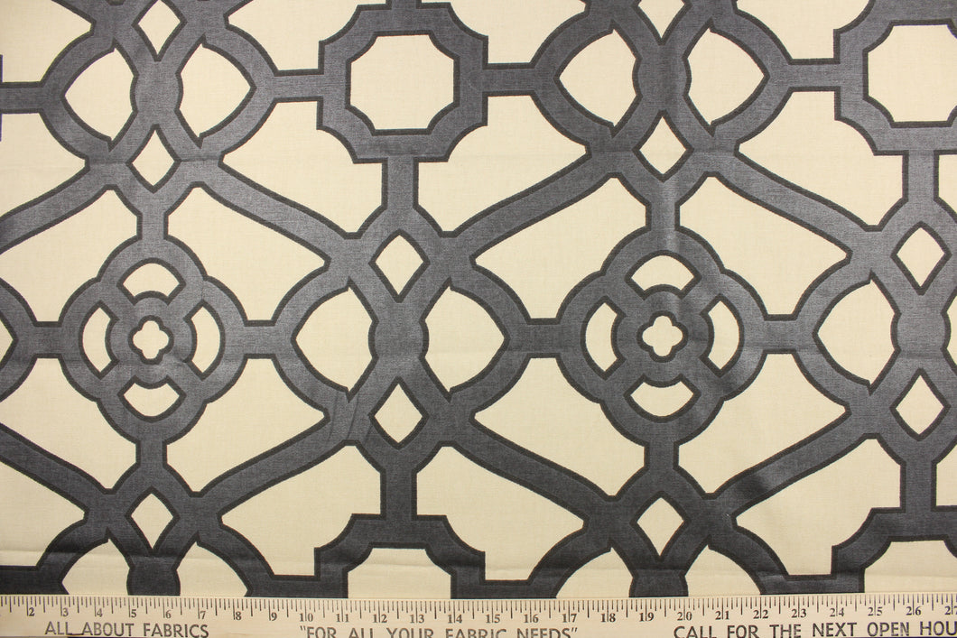  This fabric features a geometric design in a charcoal gray outline in black against a off white.