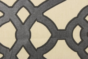  This fabric features a geometric design in a charcoal gray outline in black against a off white.