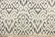 Load image into Gallery viewer, This fabric features a Ikat design in varying shades of gray and dull white.
