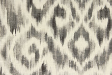 Load image into Gallery viewer, This fabric features a Ikat design in varying shades of gray and dull white.
