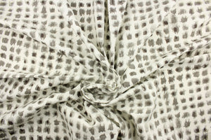 This fabric features a geometric design of small blots in gray against a white background.