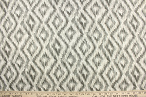 This fabric features a geometric design of diamonds in varying shades of gray against a white background.