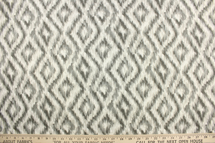 This fabric features a geometric design of diamonds in varying shades of gray against a white background.