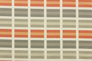 This fabric features a plaid design in orange, gray, taupe, and off white . 