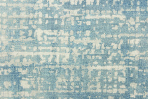  This fabric abstract design in blue, dull white and hints of gray. It has a distressed look about it enhancing the design.