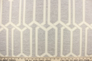 This jacquard fabric features a geometric design in gray, and white . 