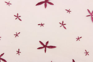 This tulle features a glittery star design dark pink against a pink background in . 