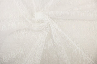This lace features a woven floral design in a iridescent and white . 