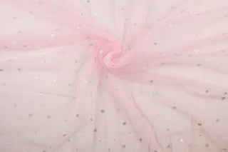 A sheer, semi firm, tulle in pink featuring silver sparkly stars