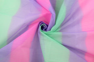 A sheer, semi firm, tulle in a purple, green and pink .