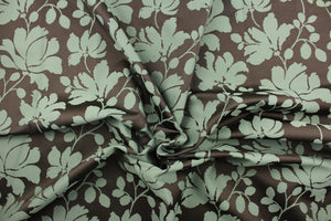 This fabric features a large-scale floral pattern in light olive green on a rich brown background.  The slight sheen enhances the design.  It would be great for home decor such as multi-purpose upholstery, window treatments, pillows, duvet covers, tote bags and more.  It has a soft workable feel yet is stable and durable.