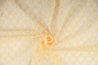 This lace features a woven floral design in golden yellow and white.