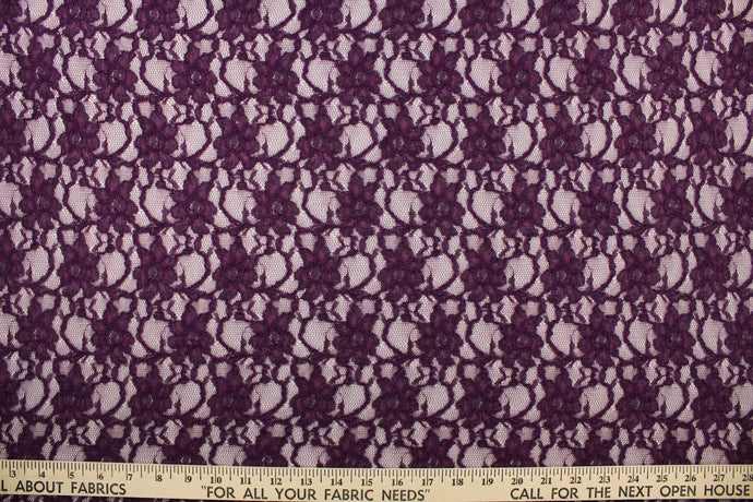 This lace features a woven floral design in a rich dark purple.