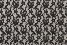 Load image into Gallery viewer, This lace features a small woven floral design in black .
