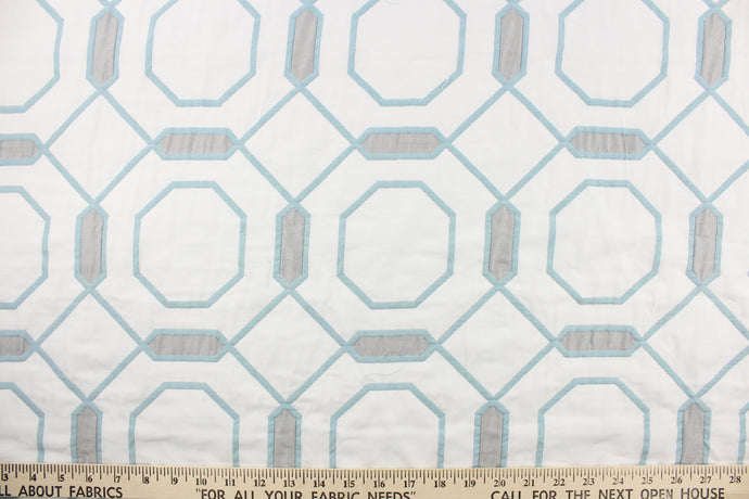 This quilted jacquard fabric features a honeycomb  design in baby blue and steel gray on a white background.  It has a matte texture and nice soft hand.  Uses include bedding, accent pillows and home decor.
