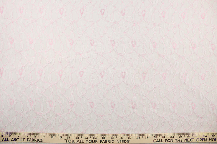  This lace features a woven floral design in light pink.