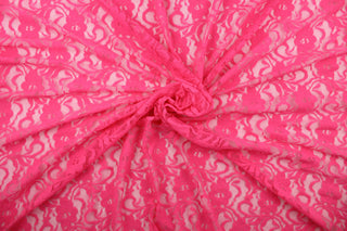 This lace features a woven floral design in bright pink.