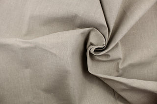 A linen fabric in a taupe gray with speckles of white .