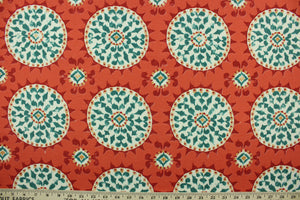  This outdoor fabric features a medallion  design in teal, golden tan, dark coral, off white, and dark red .