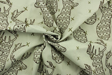 Load image into Gallery viewer, This fabric features a Elk head design in brown and olive green set against a beige background with a latex backing. 
