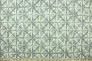  This fabric features a geometric design in gray, and off white.