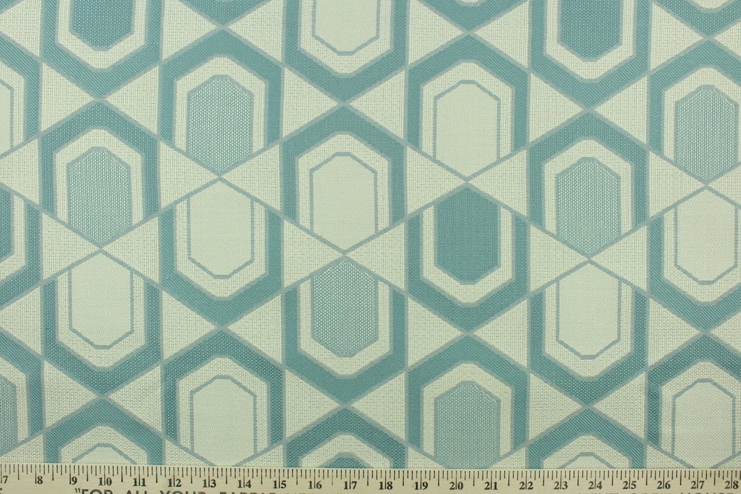  This fabric features a geometric design in gray turquoise and pale beige .
